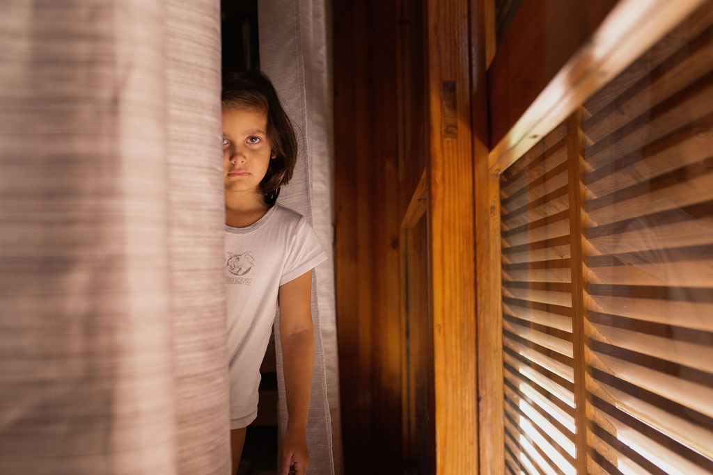 Le linee guida per fotografare dentro casa bimba che sta vicino alla finestra