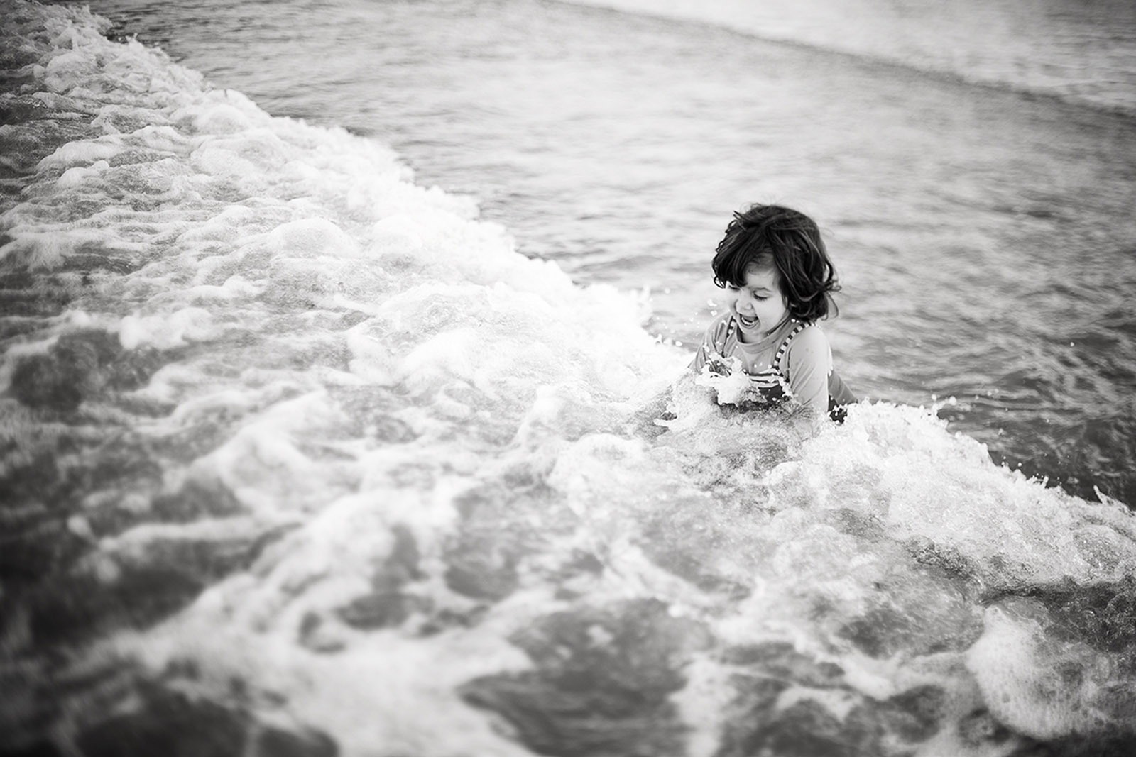 bambina che gioca con le onde bambina che gioca tra le onde
