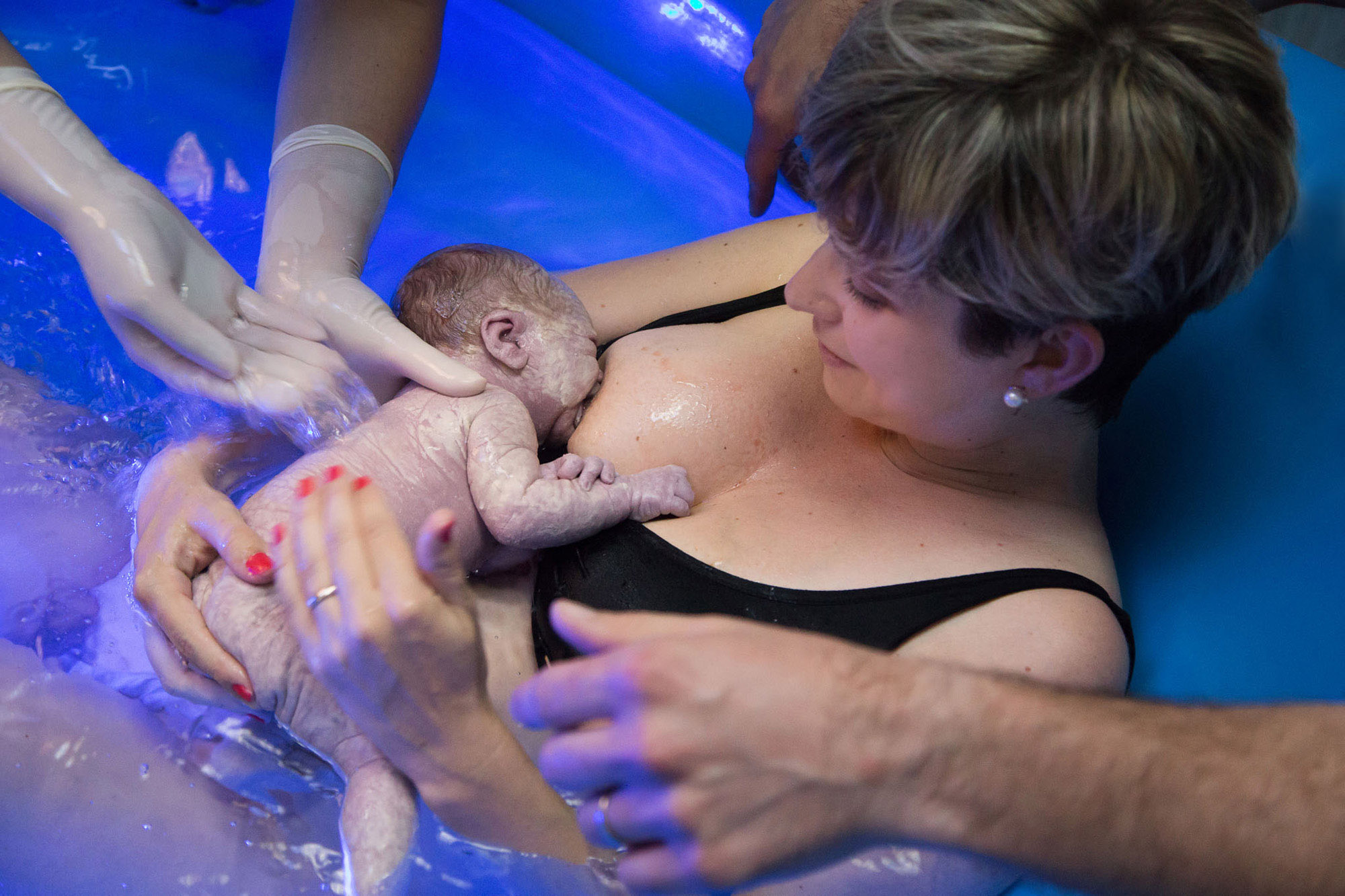 una bimba appena nata con un parto in acqua si attacca al seno della mamma