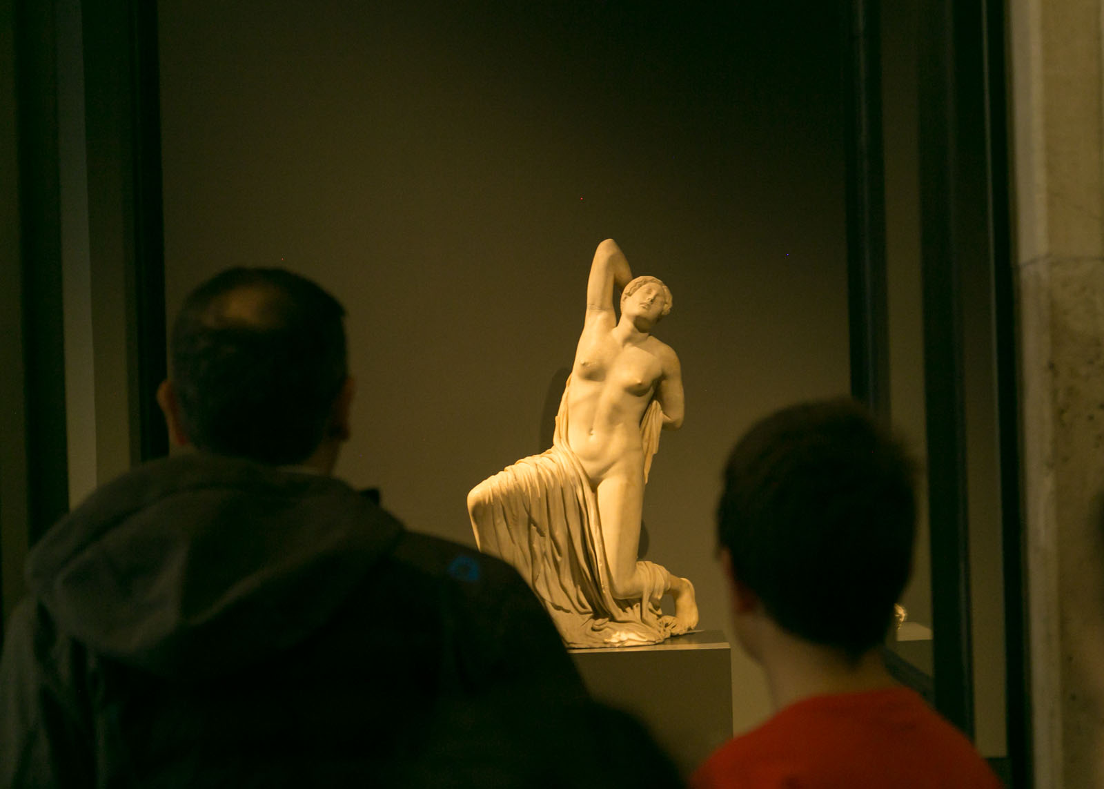 Padre che ammira insieme al figlio una scultura al museo romano di Roma