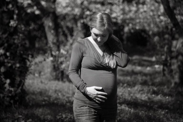 una bellisssima donna con il pancione in mezzo alla natura durante un servizio foto gravidanza Roma