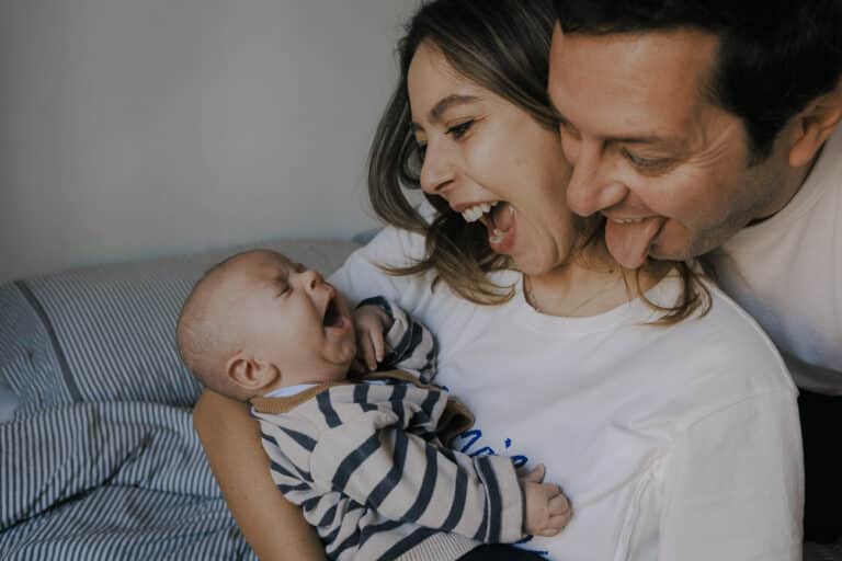Servizio fotografico neonati a domicilio: mamma, papà e il loro piccolo Elio appena nato durante un s