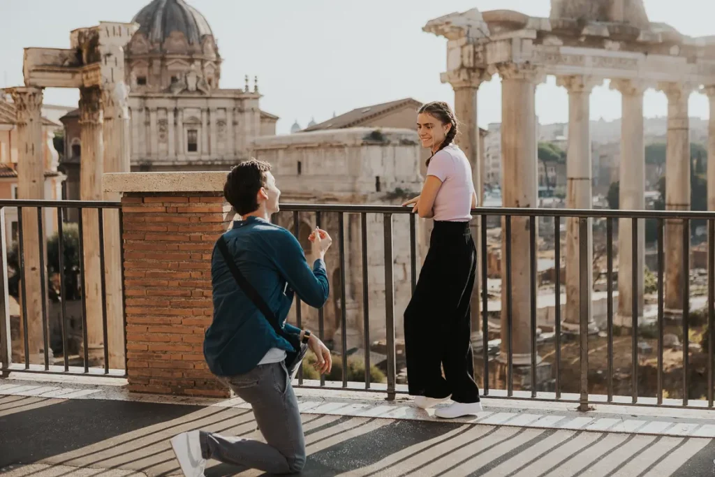 A guys is proposing at Roman Forum after having a Rome proposal planning with Alina, an engagement photographer