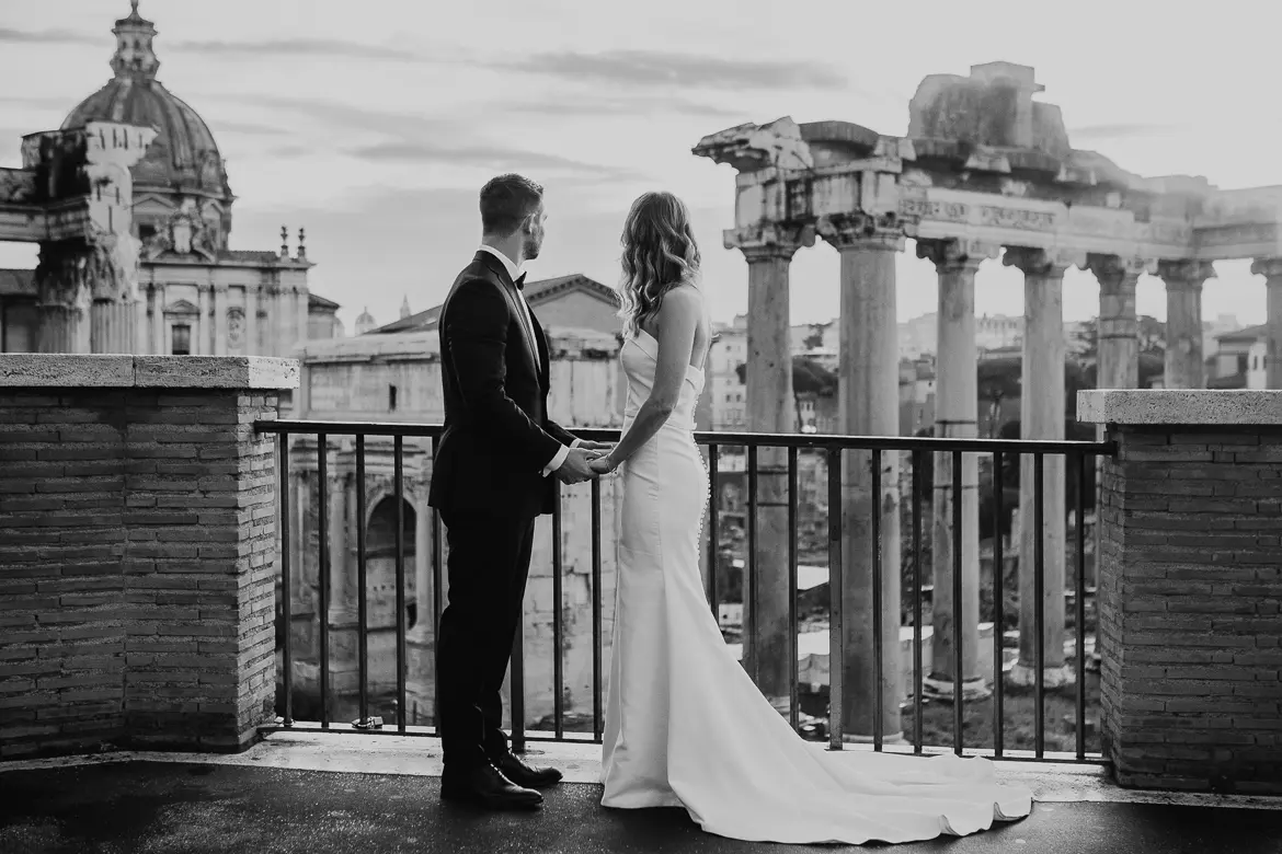 Couple is looking towrds Roman Forum ruins for a wedding & elopement photography in Rome